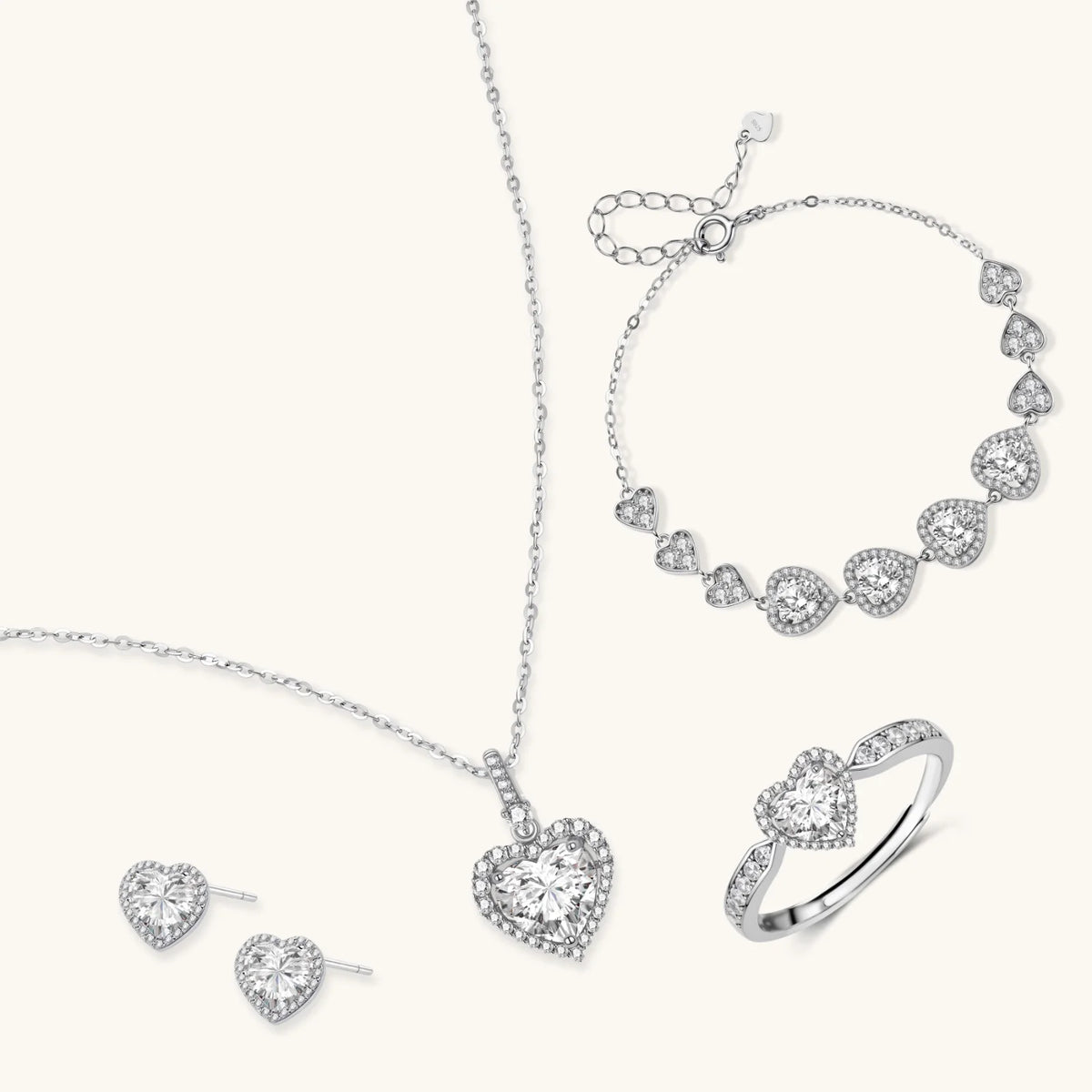 Complete jewelry set with heart-shaped sterling silver pieces featuring brilliant moissanite stones on white background.