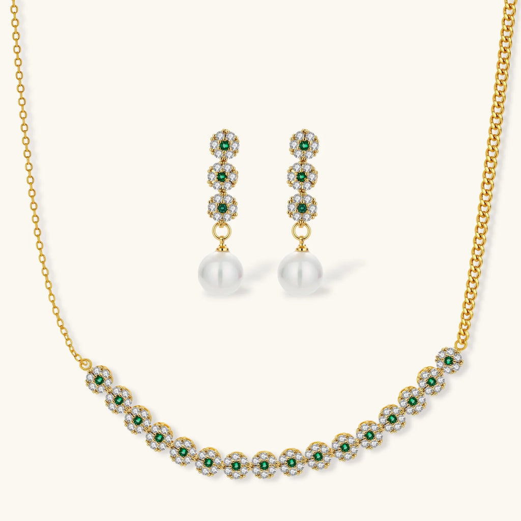 Gold-plated jewelry set with green cubic zirconia floral motifs, featuring matching necklace and pearl drop earrings