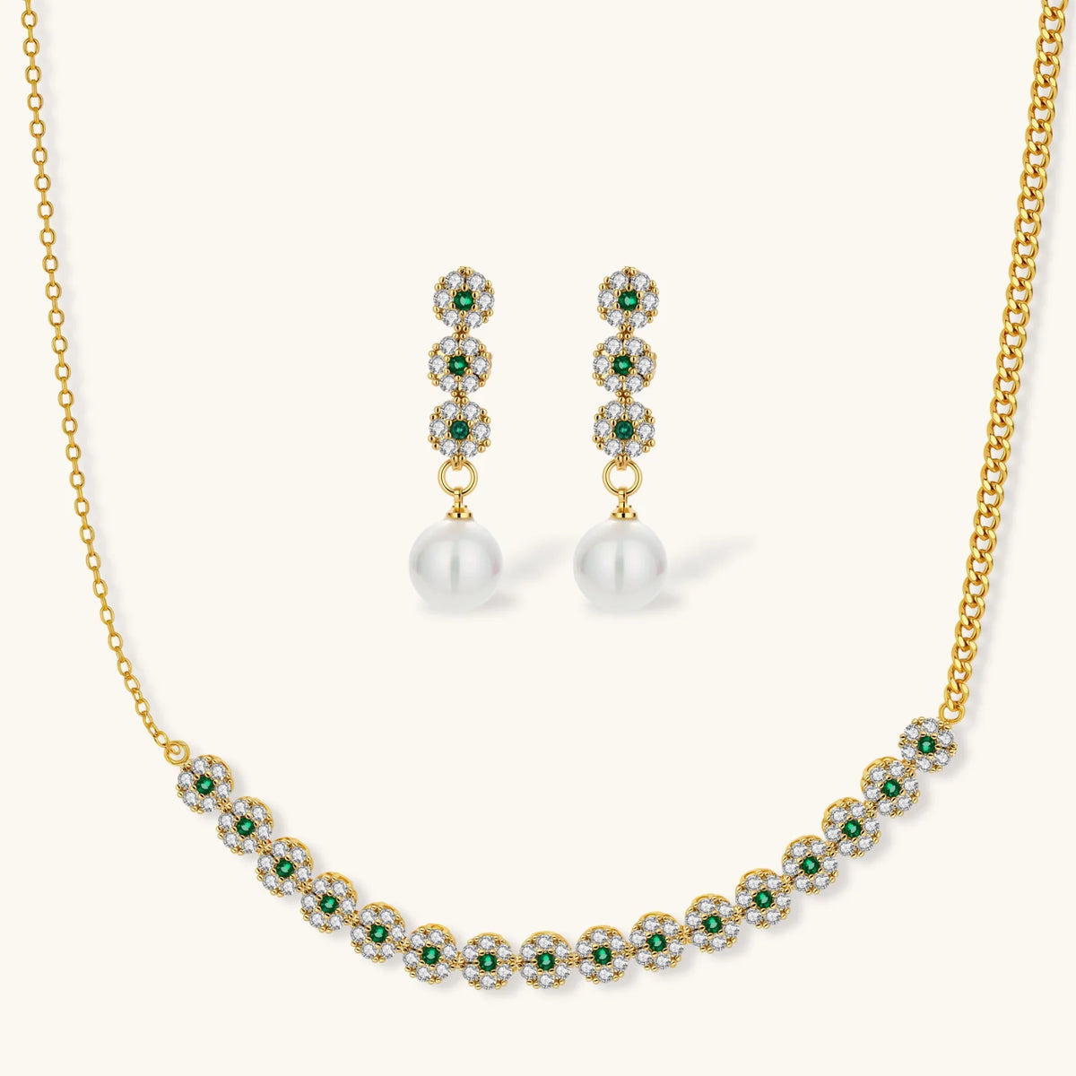 Gold-plated jewelry set with green cubic zirconia floral motifs, featuring matching necklace and pearl drop earrings