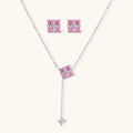 White gold plated jewelry set with pink cubic zirconia stones in geometric cross design, featuring Y-necklace and square stud earrings