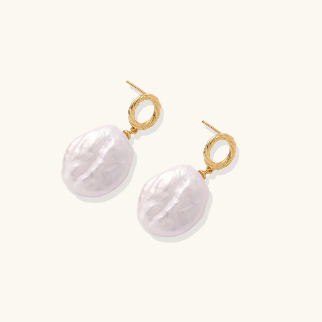 18K gold vermeil twisted circle studs with organic white baroque pearl drops on cream background