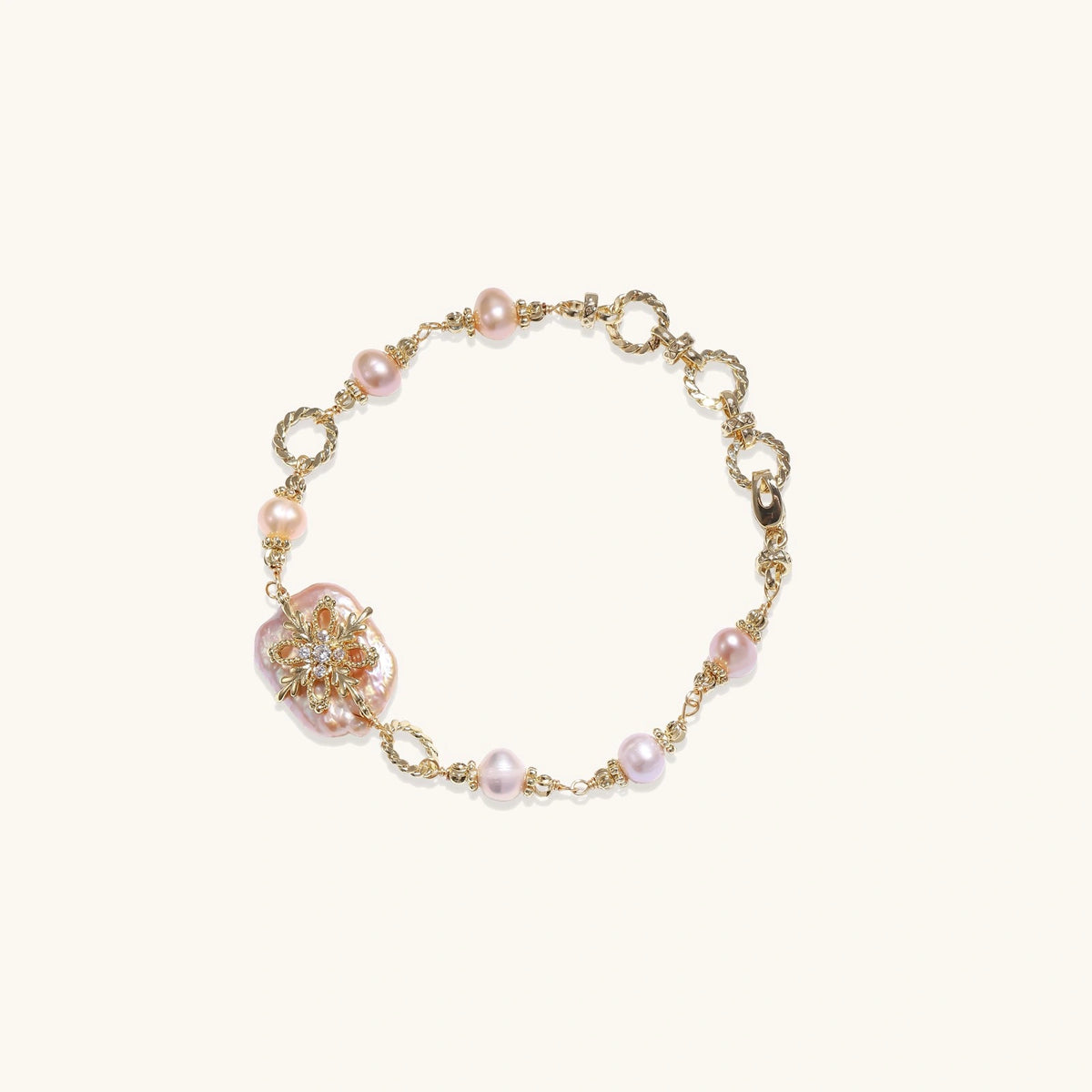 Gold-plated bracelet with pink baroque pearl centerpiece, floral connector, and freshwater pearls